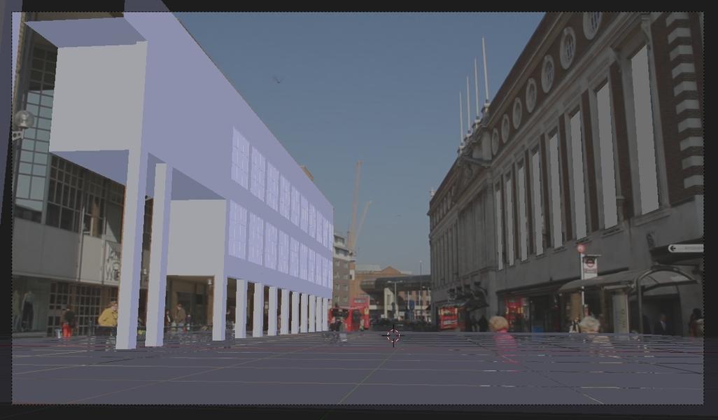 A screenshot of a low-poly building from the camera view in Blender 3D, overlaid over a frame of video of a street. The camera is looking down the street with a shopping centre on each side of it. One of the shopping centres is covered by the low-poly building.